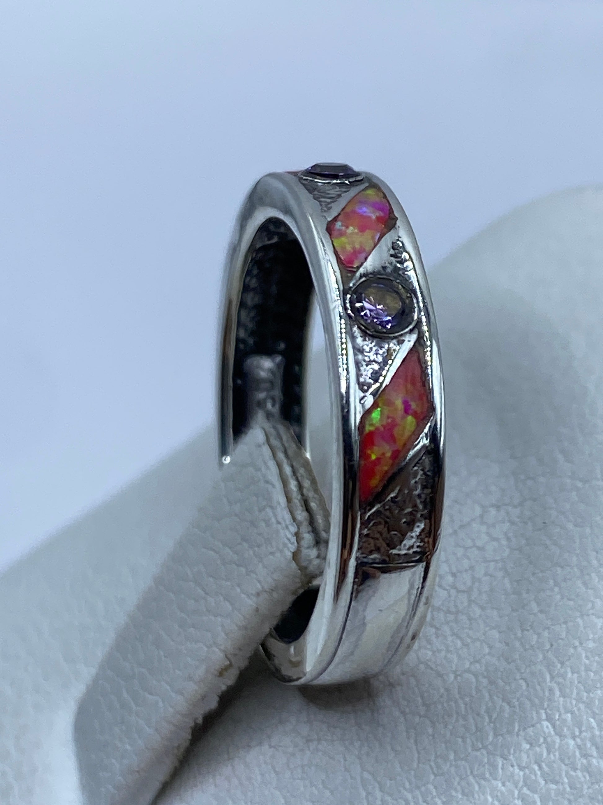 Anillo colocado en mano mostrando cómo el ópalo cambia de tonos con la luz