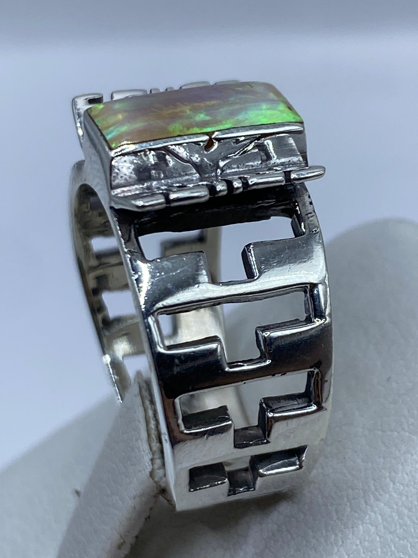 Anillo prehispánico de plata visto desde el lateral, mostrando el calado geométrico