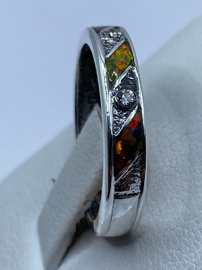 Ópalo multicolor refractando luz en tonos rojo, verde y amarillo en el anillo