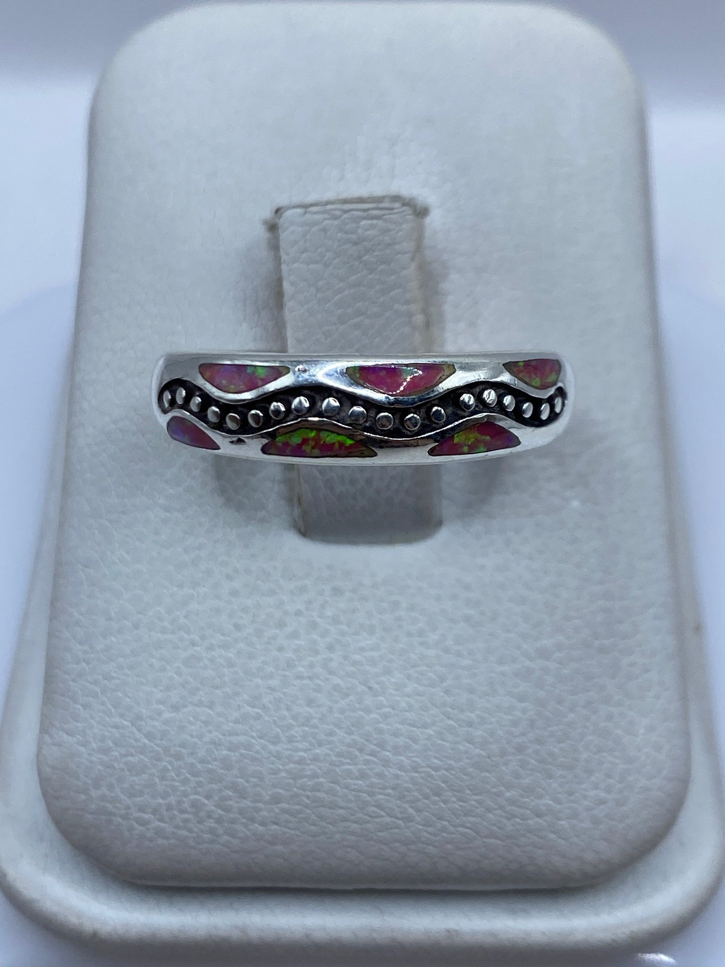 Anillo de plata .950 con ópalo de fuego rosa engastado a mano, visto de frente en estuche