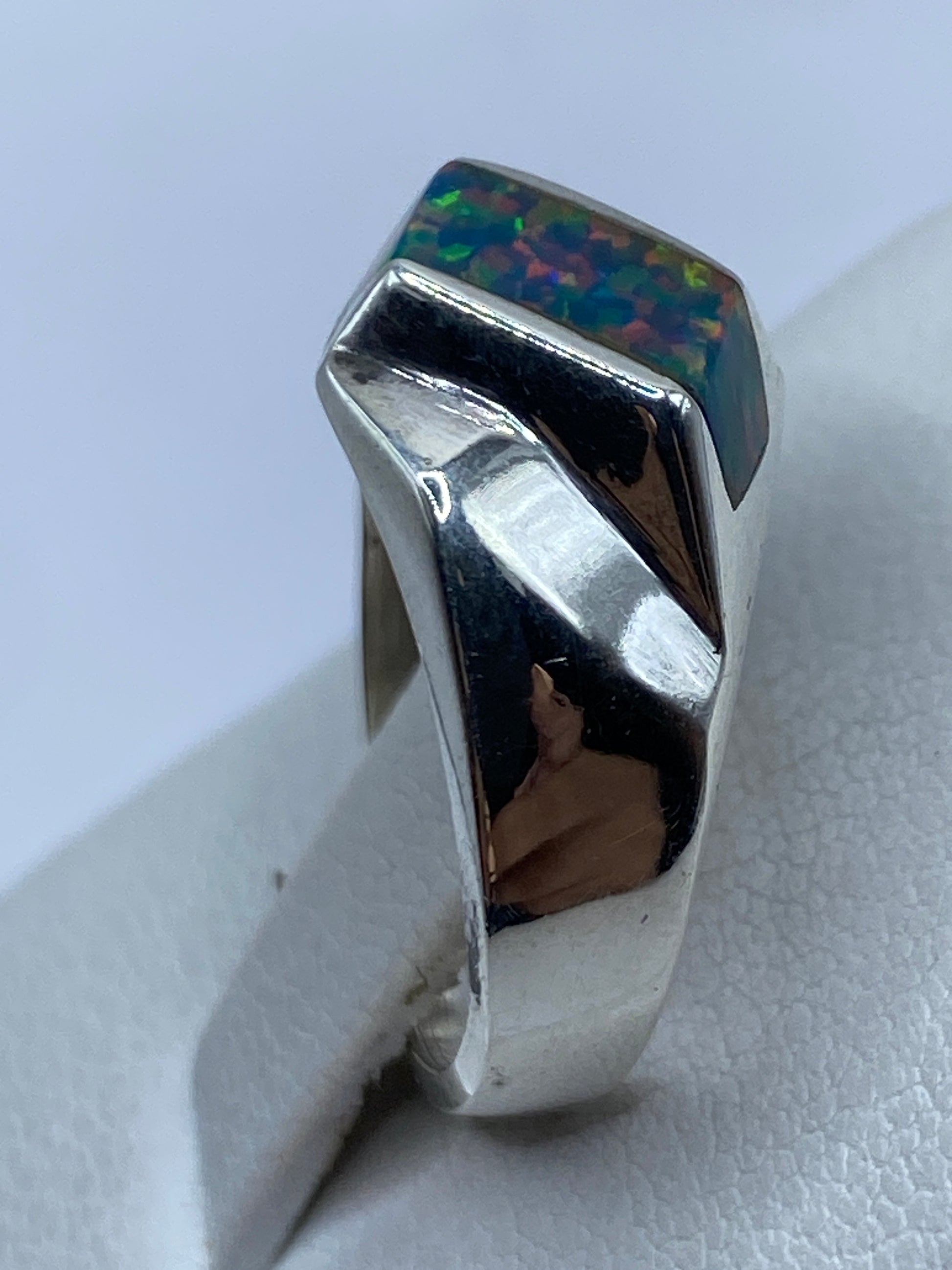 Anillo en dedo mostrando el contraste entre la plata pulida y el resplandor de la piedra