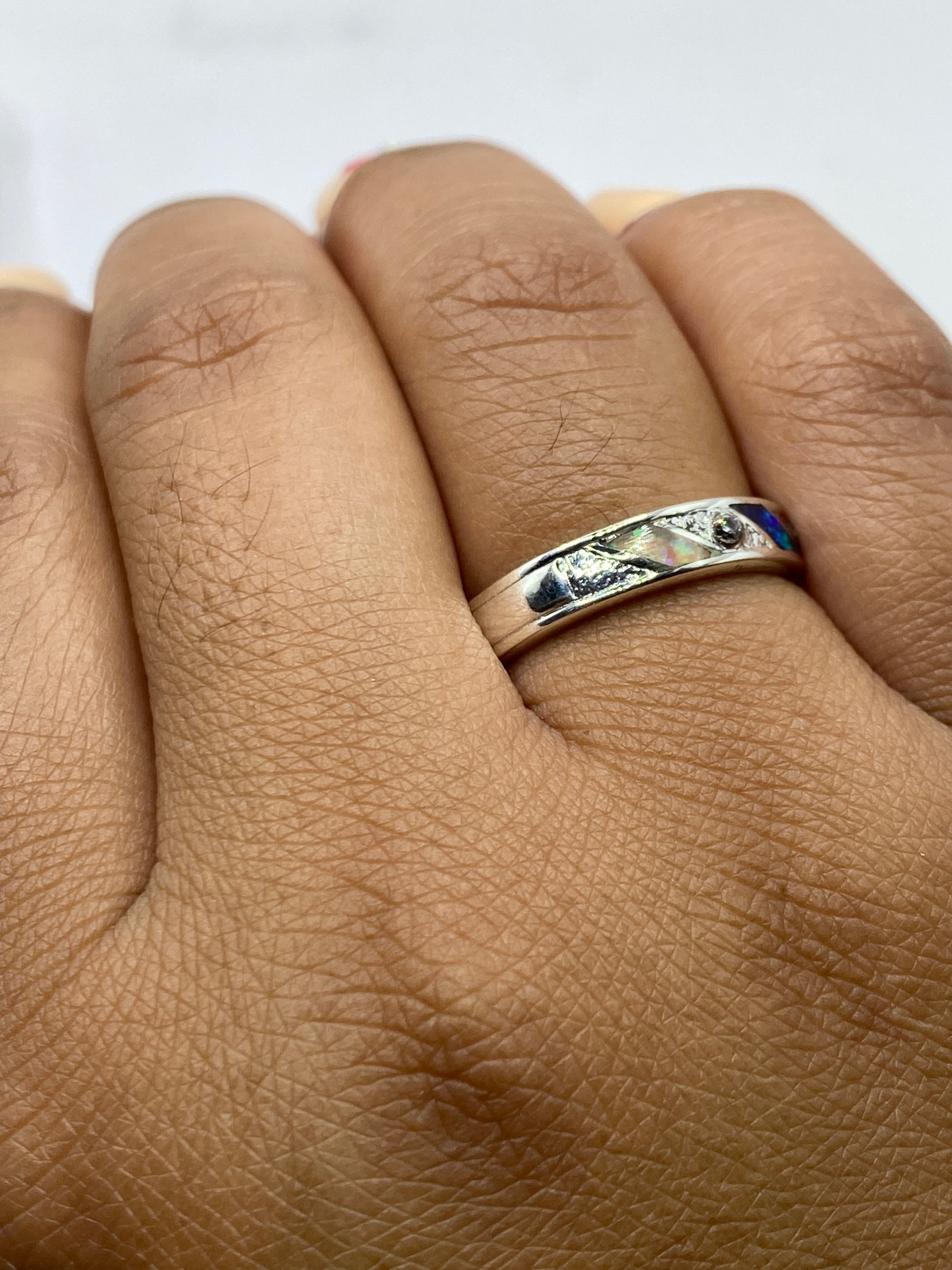 Anillo puesto en dedo mostrando el juego de colores del ópalo de fuego