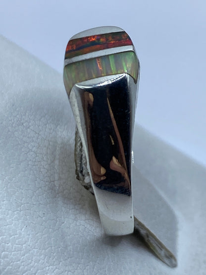 Anillo en la mano mostrando el brillo multicolor del ópalo de fuego