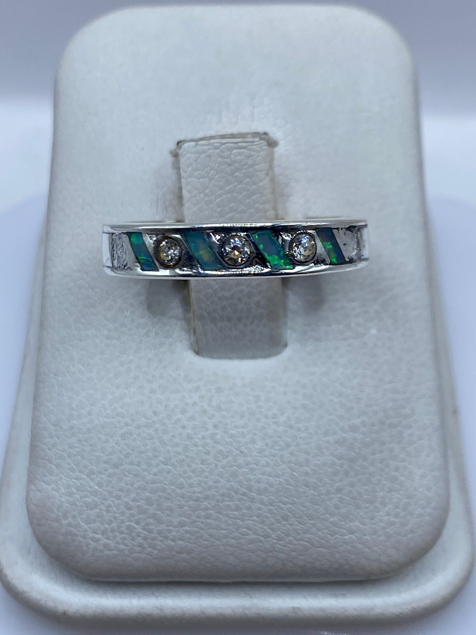 Anillo de plata .950 con Ópal de Fuego azul cielo, engastado en banda minimalista en la mano de una persona