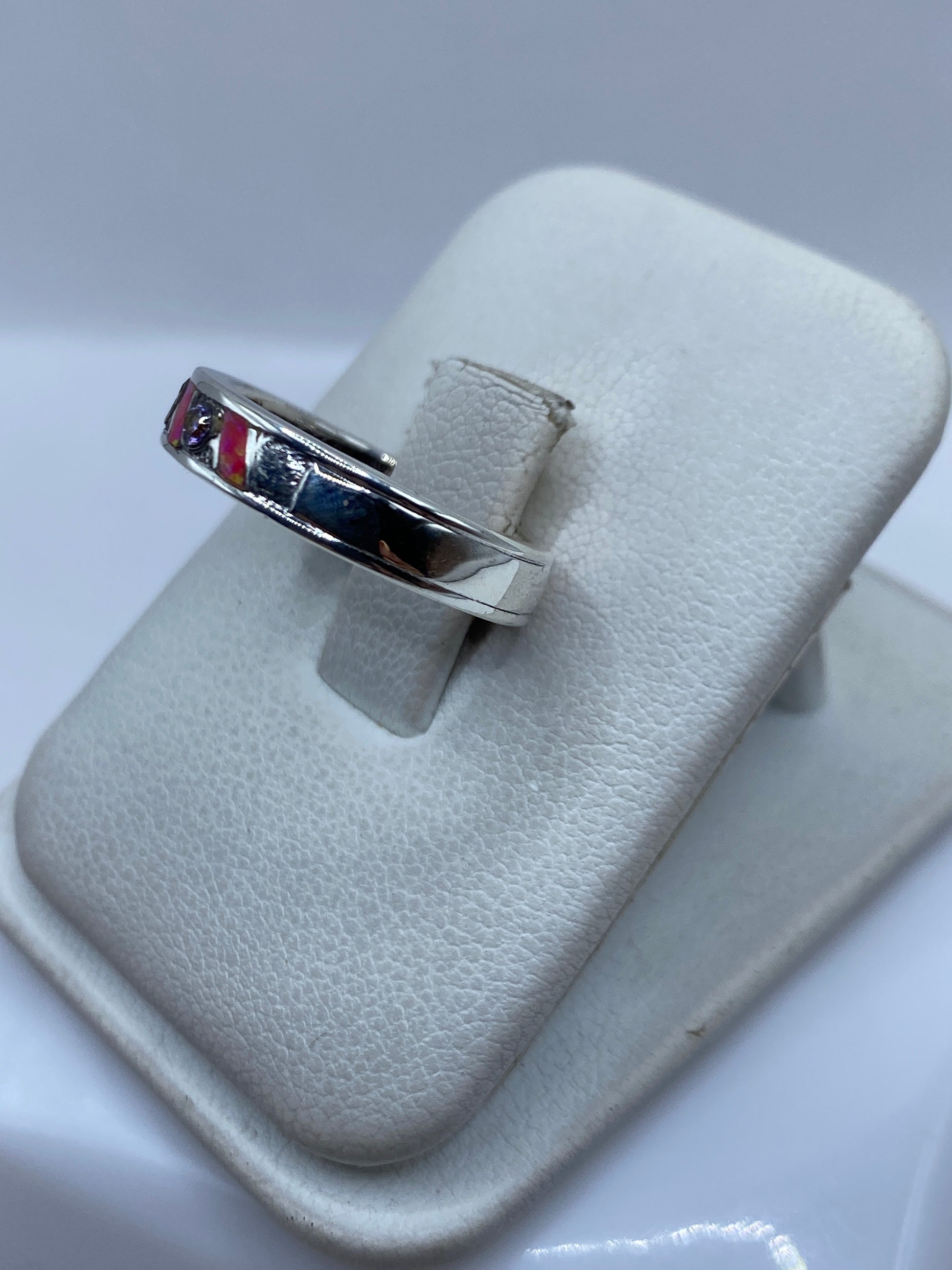 Detalle del ópalo de fuego rosa brillando con tonos cálidos en el anillo