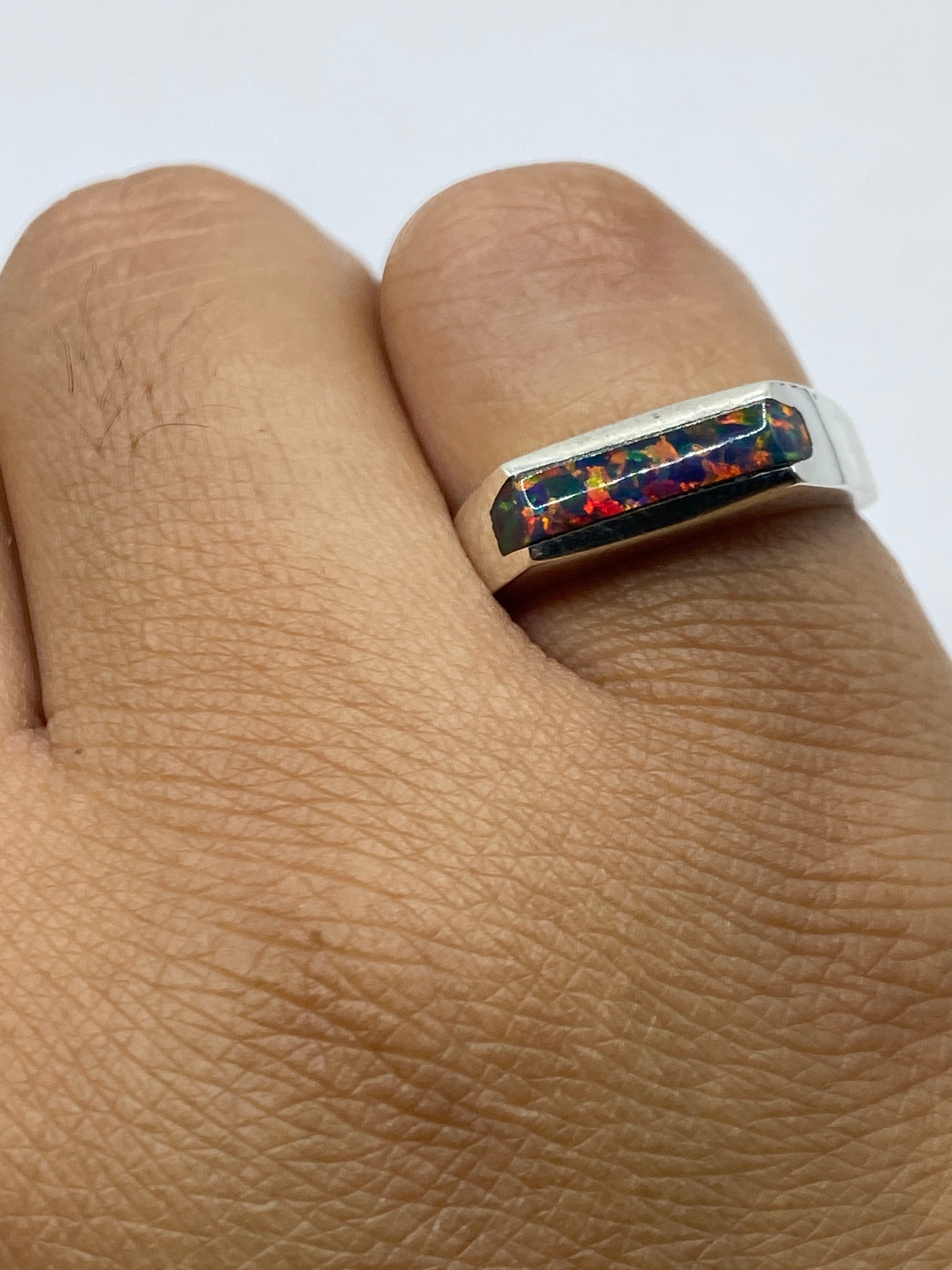Anillo en la mano mostrando los colores cambiantes del ópalo de fuego bajo la luz