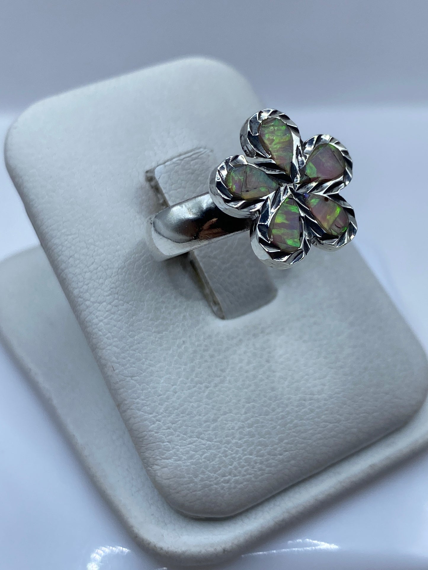 Vista lateral del anillo floral con ópalo de fuego mostrando el engaste a mano en plata .950