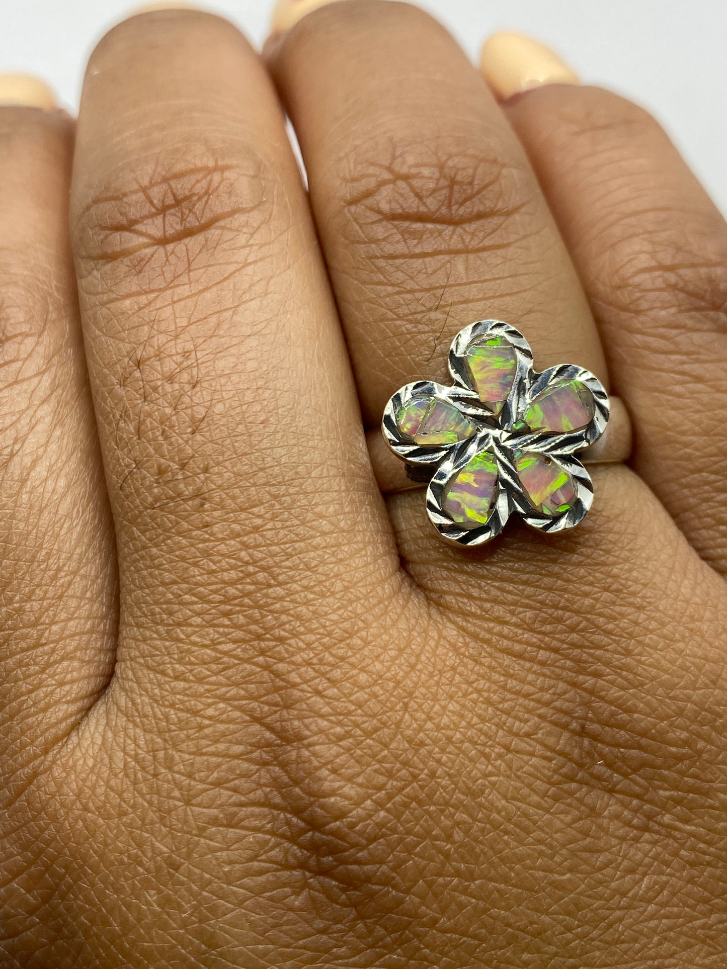 Anillo sobre fondo oscuro mostrando el Quinto .950 grabado y el volumen del diseño de cinco pétalos