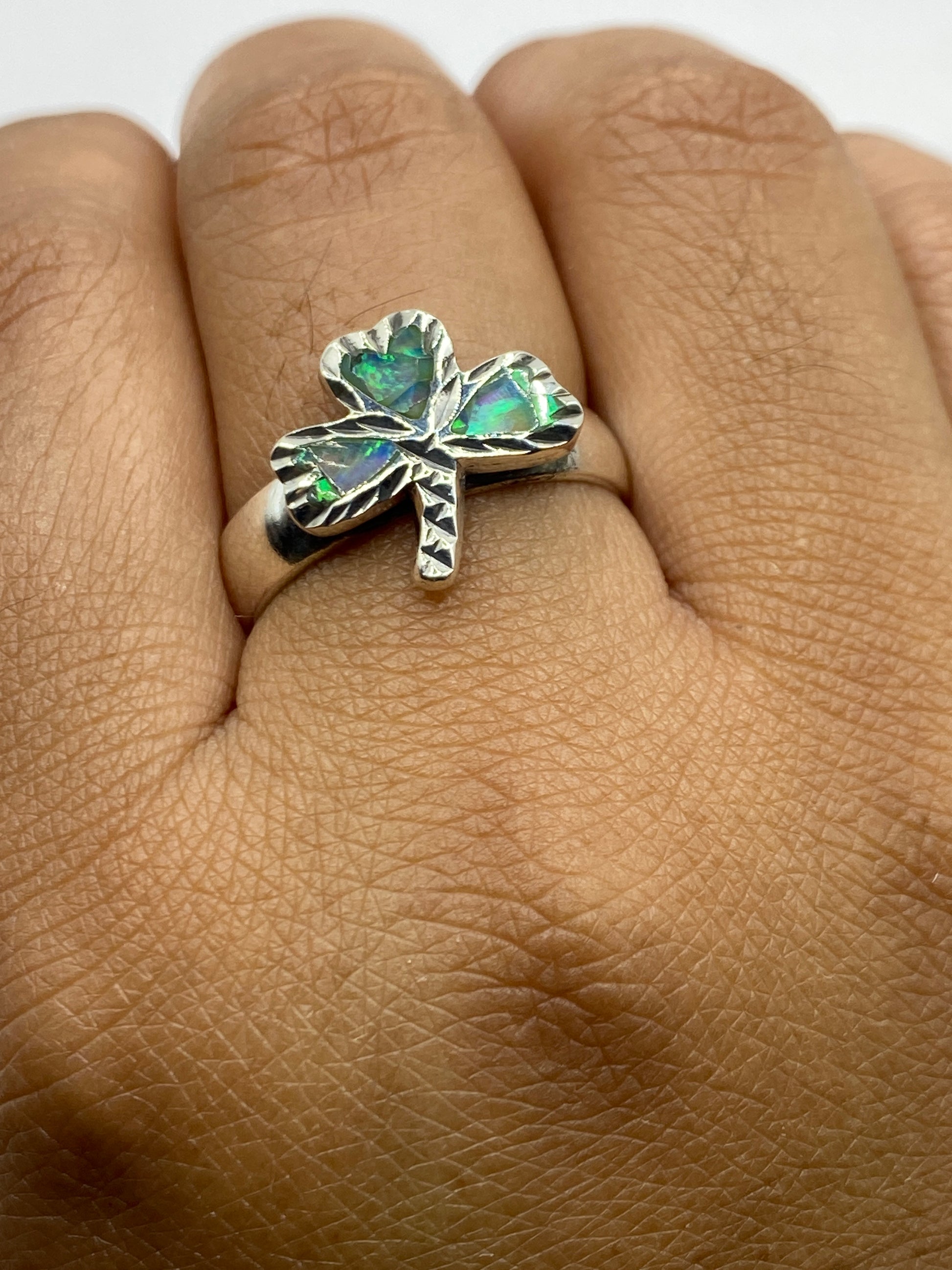 Anillo en la mano mostrando la luminiscencia natural del ópalo de fuego