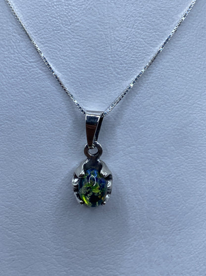 Dije de plata con piedras multicolor en cadena de plata sobre fondo blanco