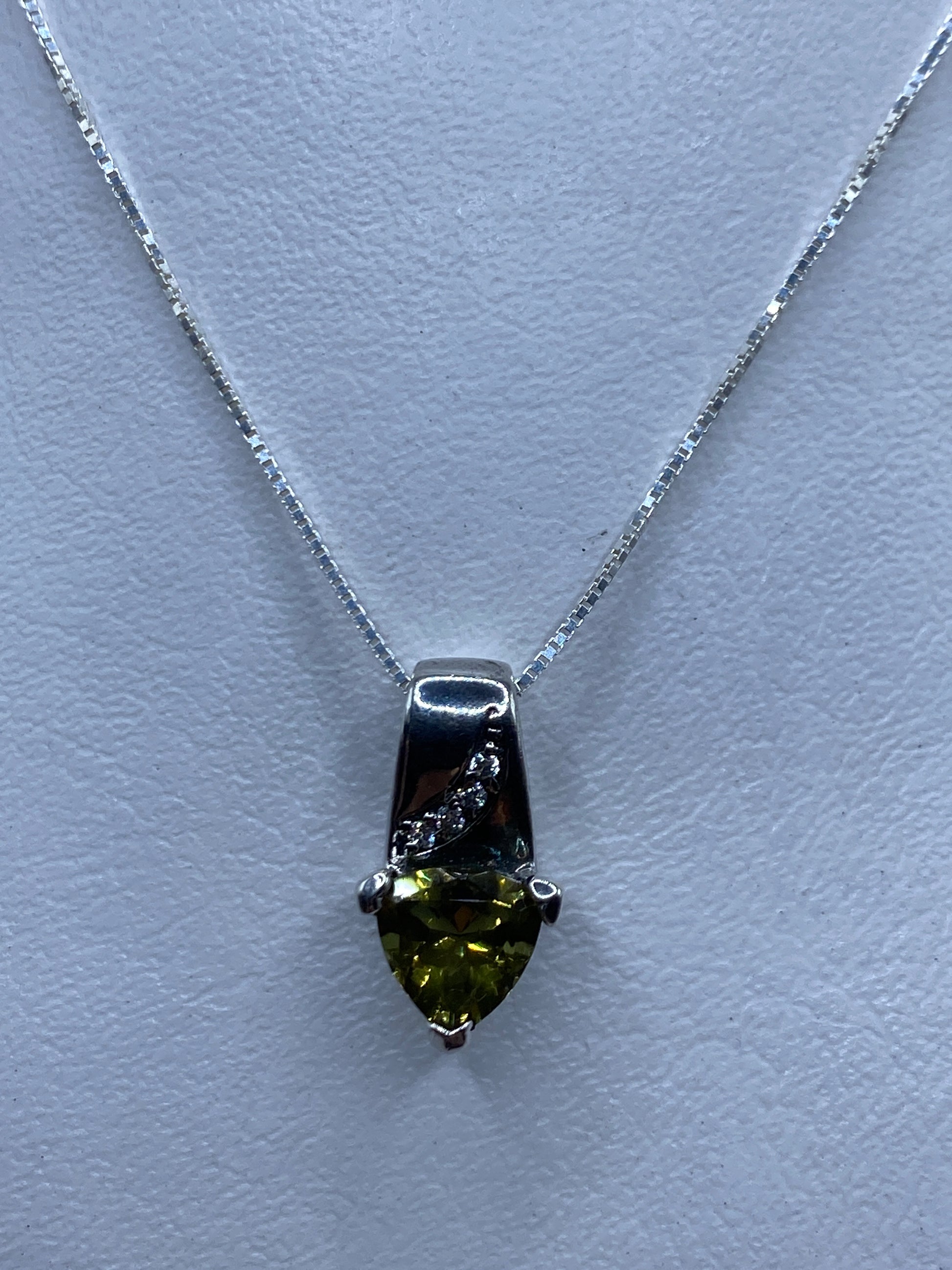 Dije de plata con circonia verde olivo brillante sobre collar blanco