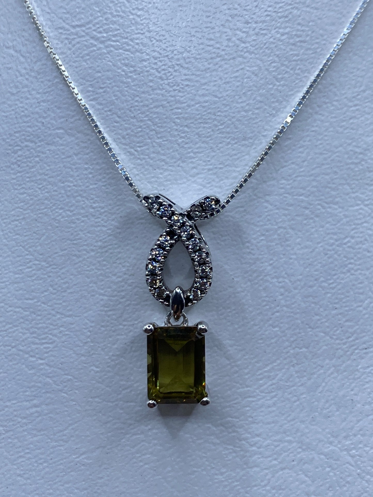 Dije de plata con lazo filigranado y circonia rectangular brillante, colgado en cadena de plata
