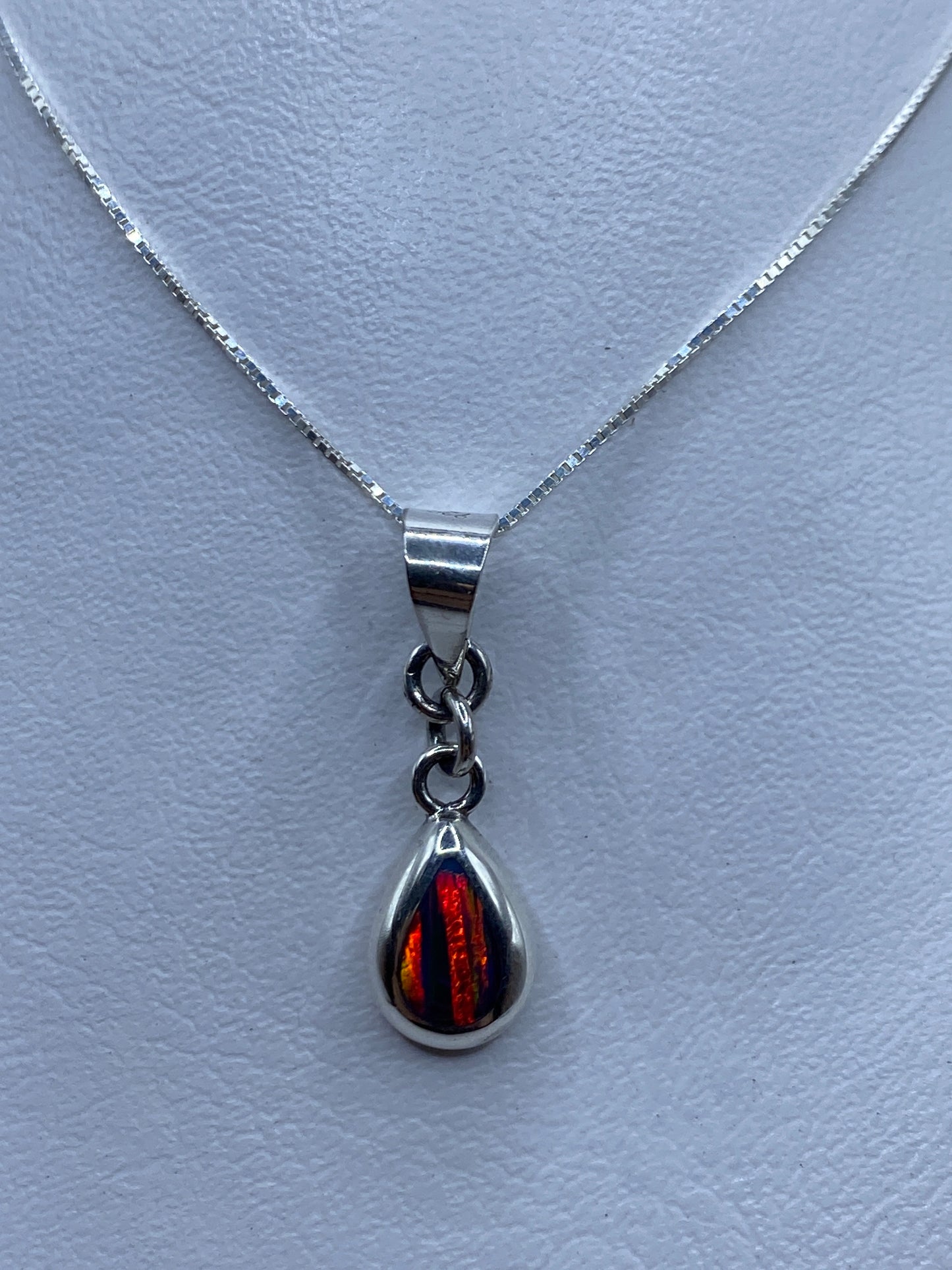 Dije de plata con ópalo de fuego rojo anaranjado en forma de lágrima, colgando de cadena