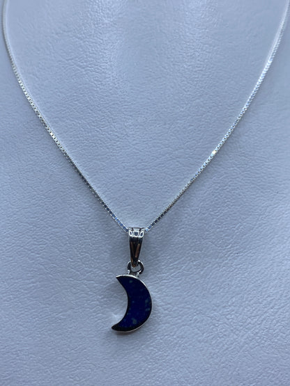 Dije luna en plata .925 con piedra azul engastada, colgando de cadena de plata