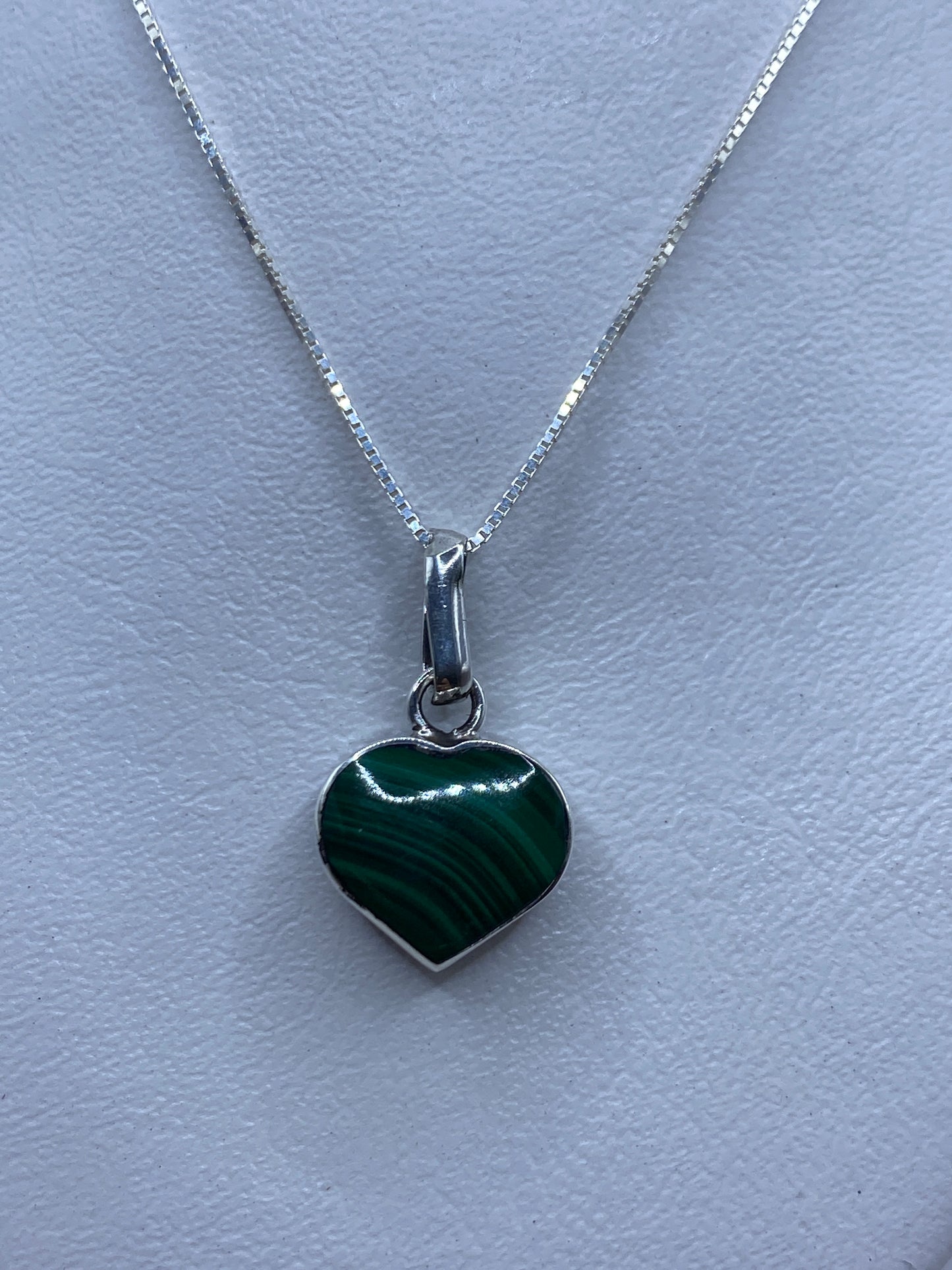 Dije de plata en forma de corazón con malaquita verde natural, sobre fondo blanco