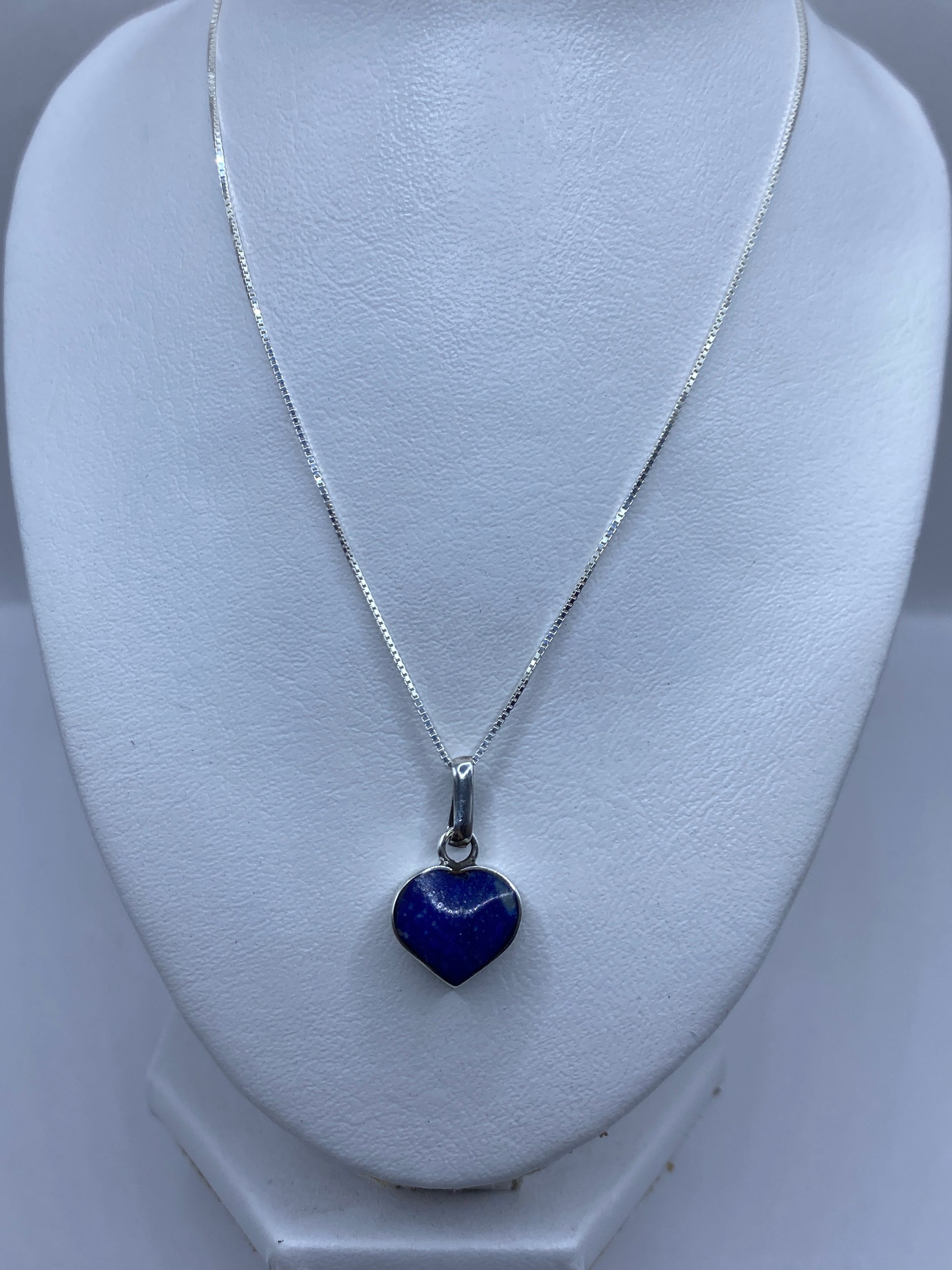 Dije de corazón en plata .950 mostrando el Quinto y la incrustación de piedra