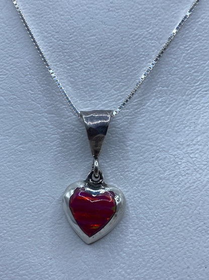 Dije de plata en forma de corazón con opalo de fuego rosa en el centro