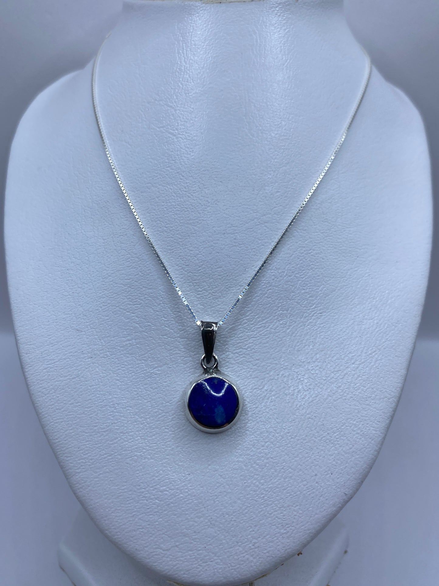 Dije de plata .925 con piedra azul en modelo blanco, detalle frontal del engaste