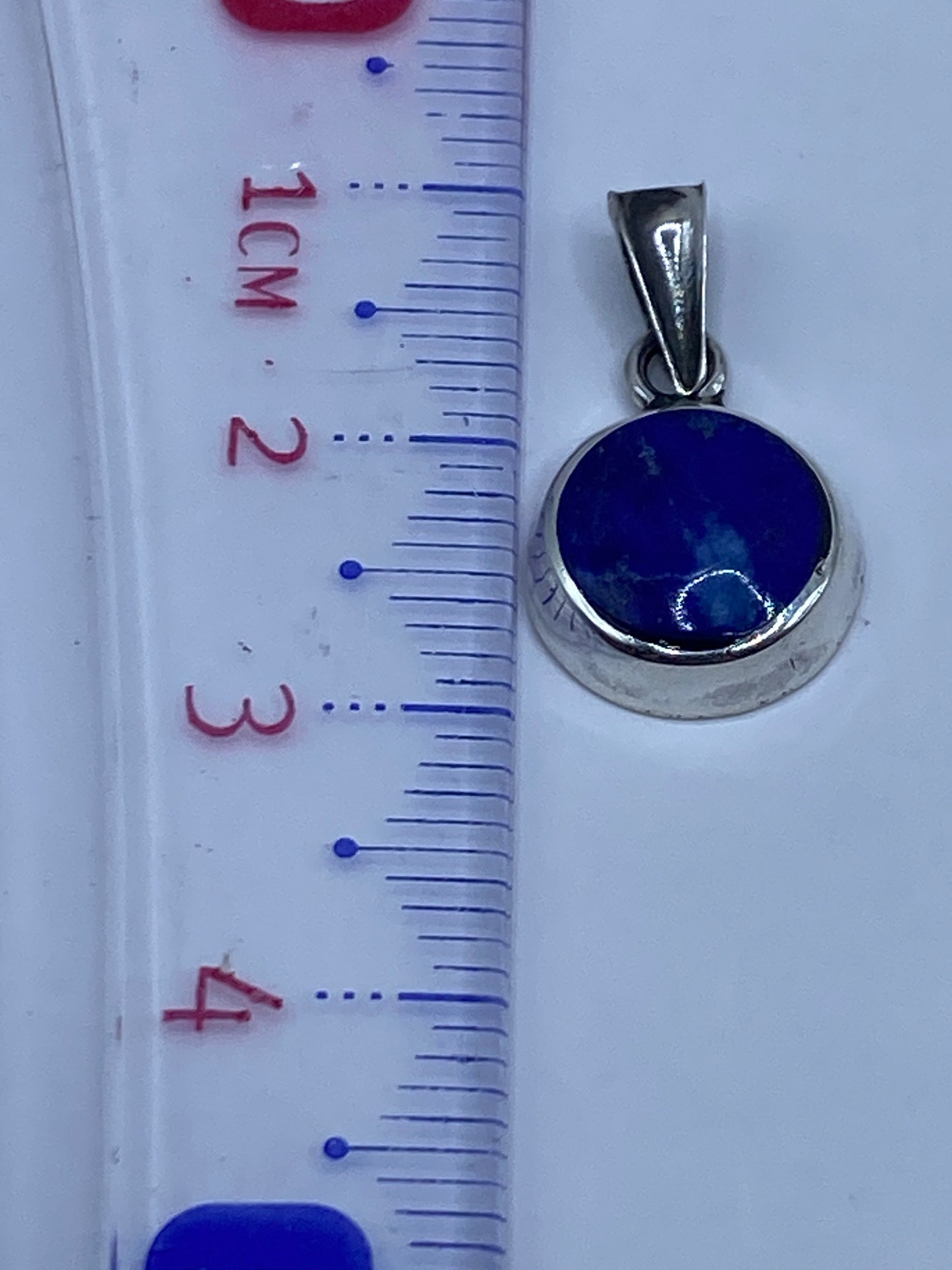 Dije medido en regla: diámetro aproximado 2.8 cm, peso 1.1 gramos