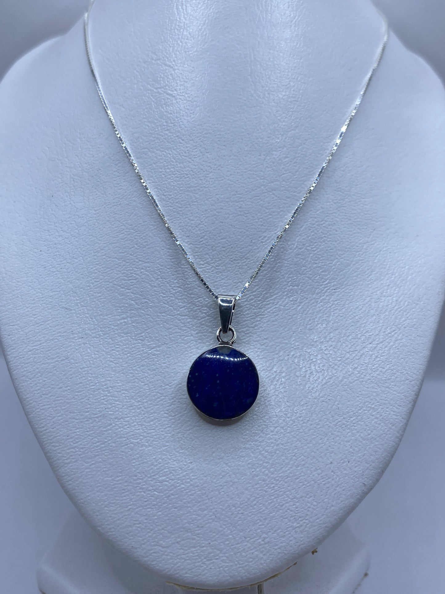 Dije minimalista visto en maniquí con cadena de plata