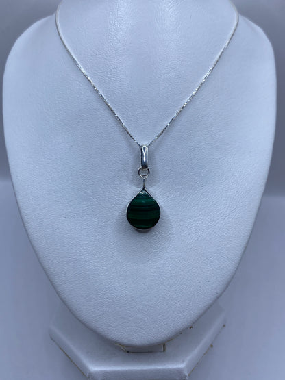 Detalle del verde con vetas de la malaquita en el dije de Taxco