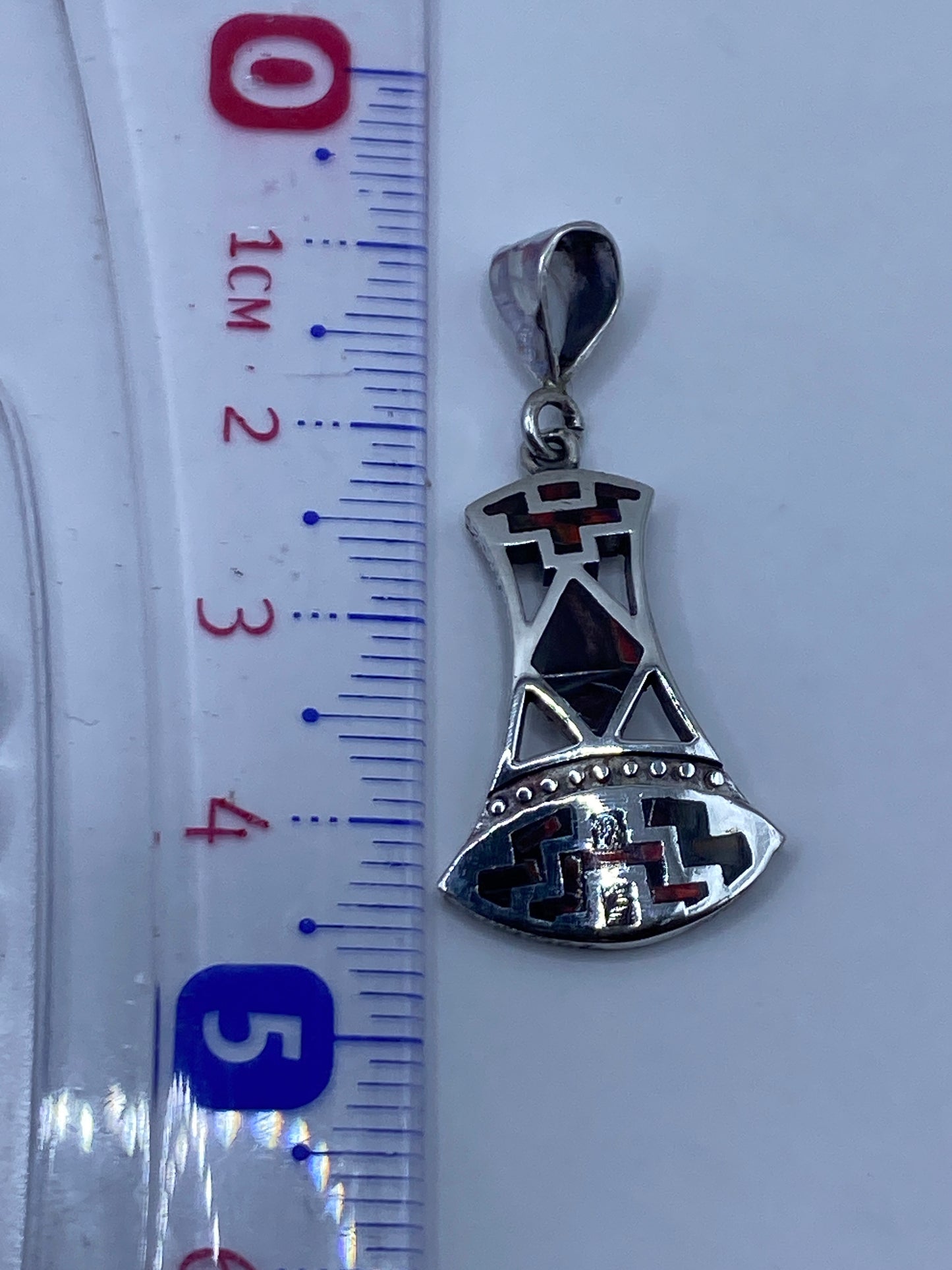 Reverso del dije mostrando el Quinto .950 y la incrustación de piedra a mano