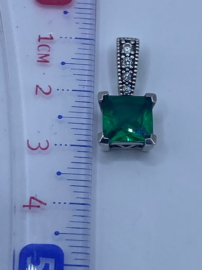 Dije de 3.1 cm de largo junto a regla de medición para referencia de escala