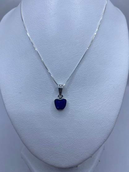 Detalle del dije mostrando el engaste de piedra azul en plata pulida