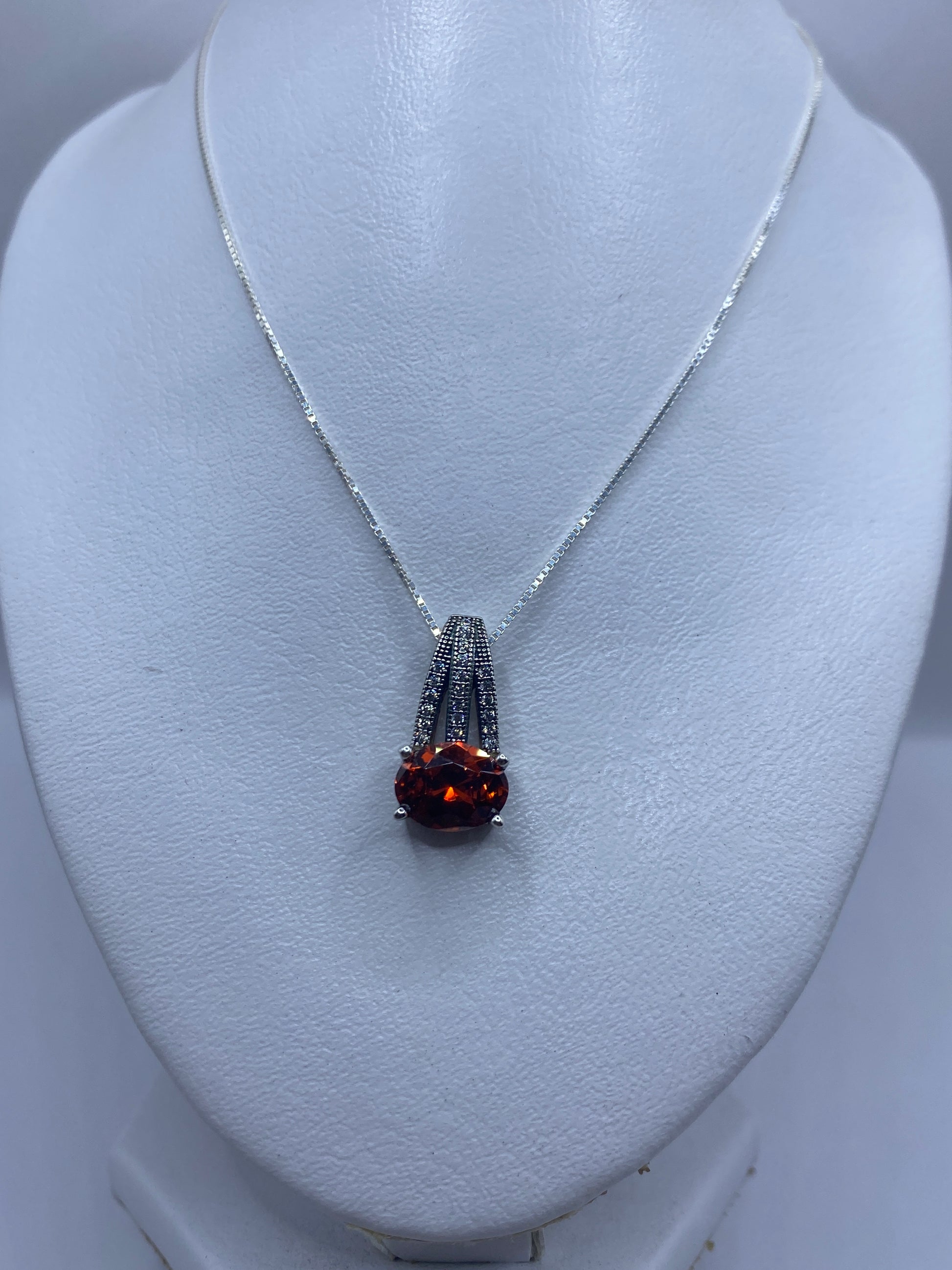 Detalle del dije de 2.6 cm mostrando la circonia naranja engastada en plata .925