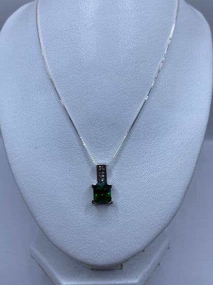 Dije de plata compacto visto de frente mostrando el brillo de la piedra