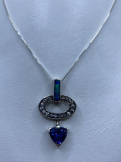 Dije de plata .925 con ópalo de fuego azul en forma ovalada, colgando de cadena de plata