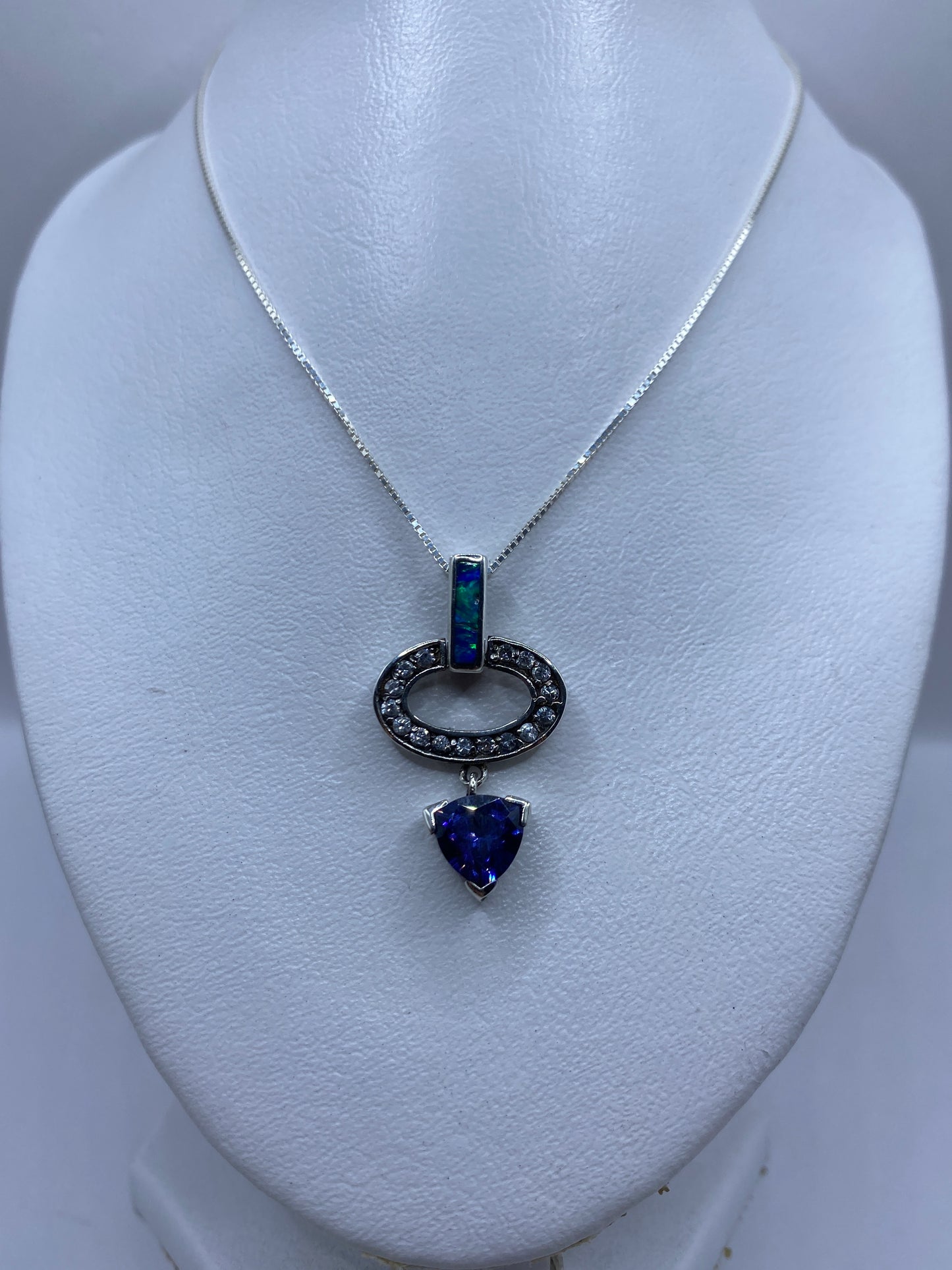 Detalle del ópalo de fuego azul engastado en plata, mostrando el brillo natural de la piedra