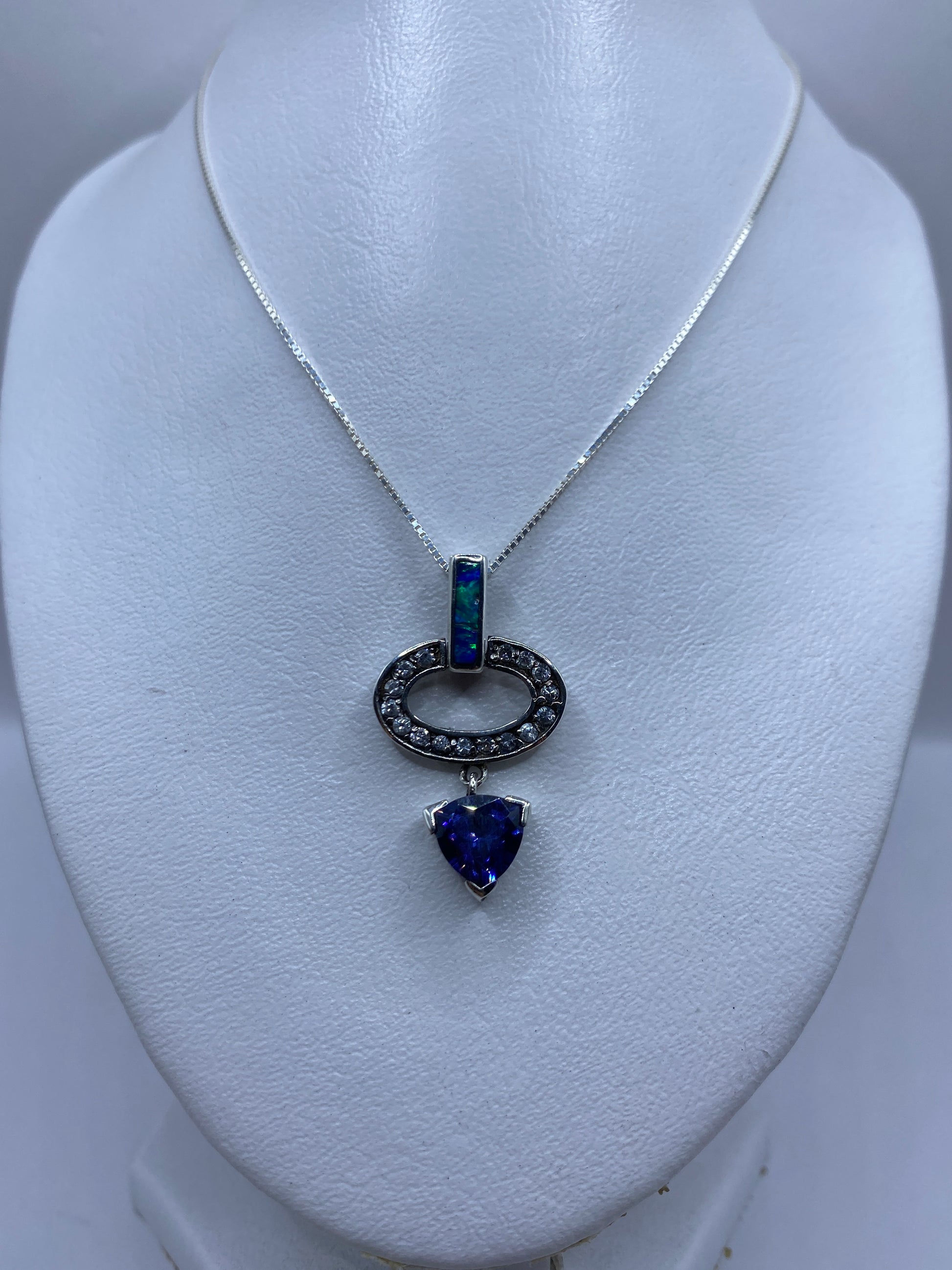 Detalle del ópalo de fuego azul engastado en plata, mostrando el brillo natural de la piedra