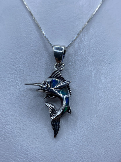 Dije de pez espada en plata .925 con ópalo de fuego azul, colgando de cadena de plata fina