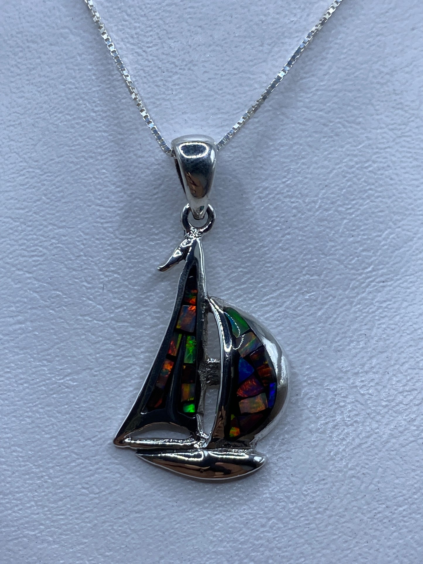 Dije de plata barco con ópalo de fuego multicolor colgando de cadena de plata