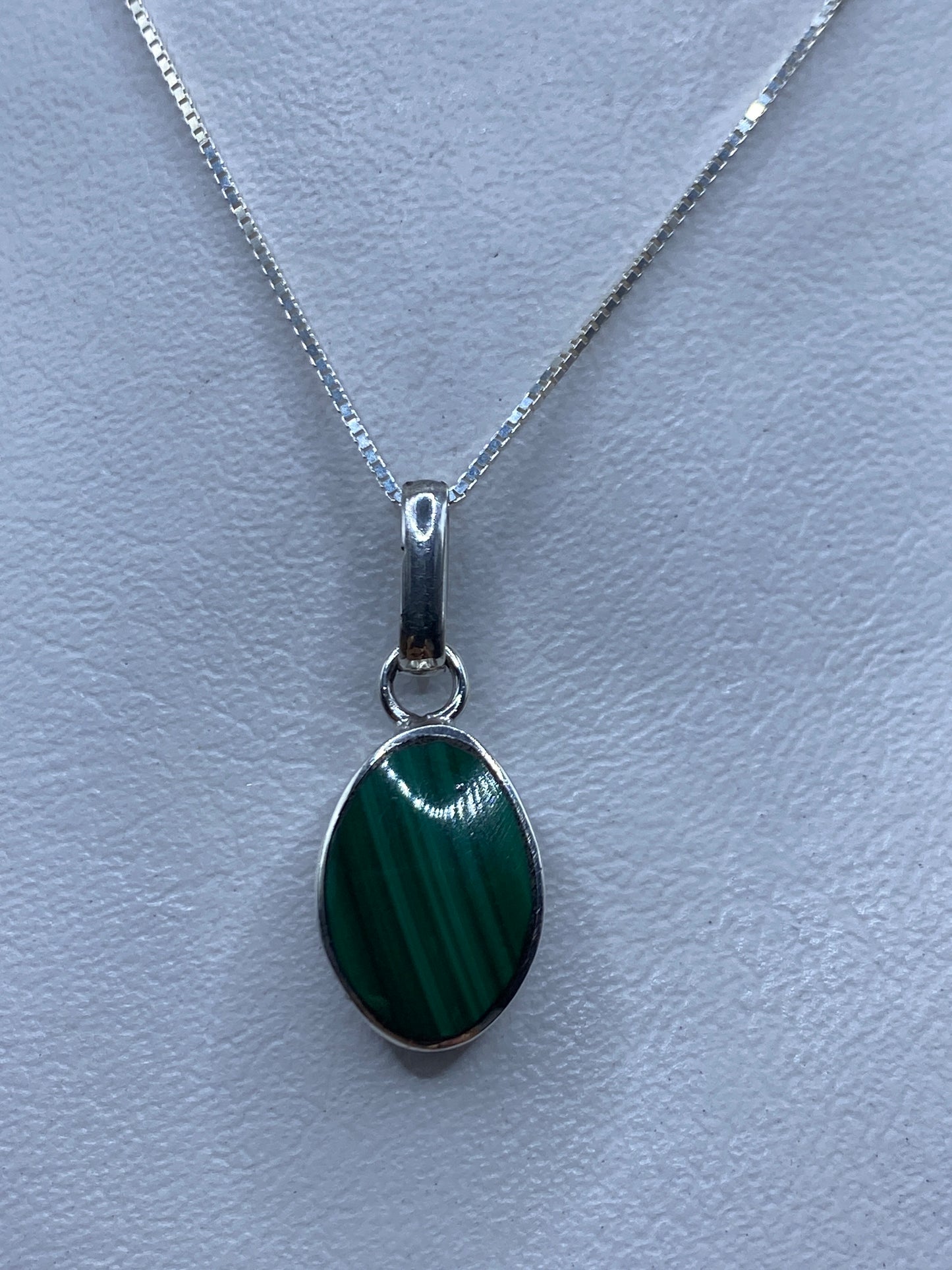 Detalle de la malaquita verde con vetas naturales engastada en plata