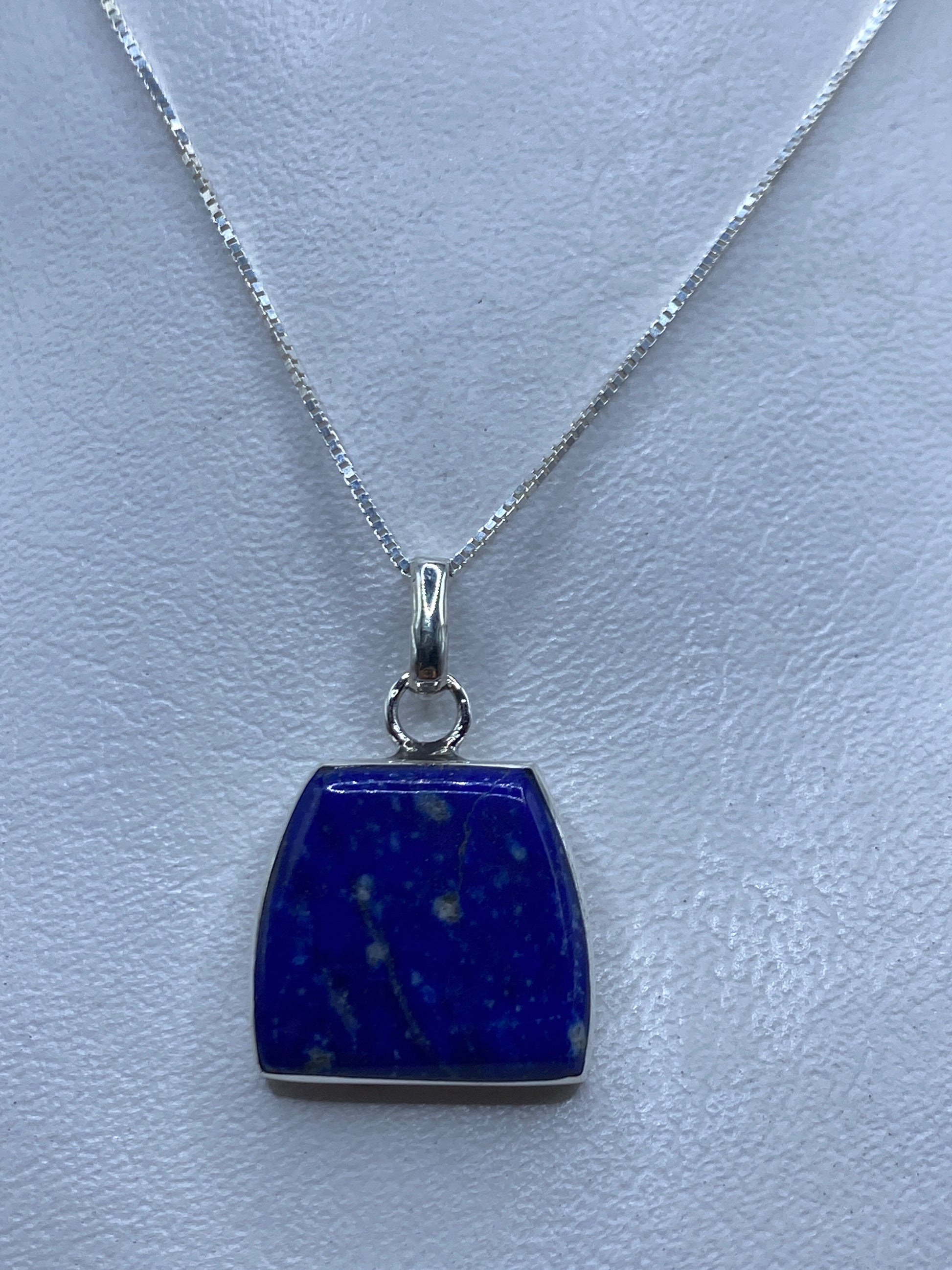 Dije de plata .950 engastado con piedra azul, colgado en cadena delgada de plata
