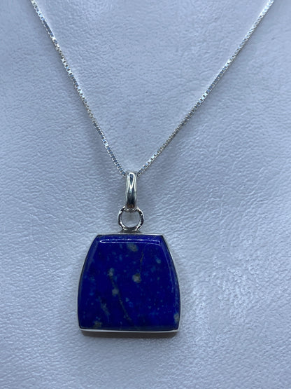 Dije de plata .950 engastado con piedra azul, colgado en cadena delgada de plata