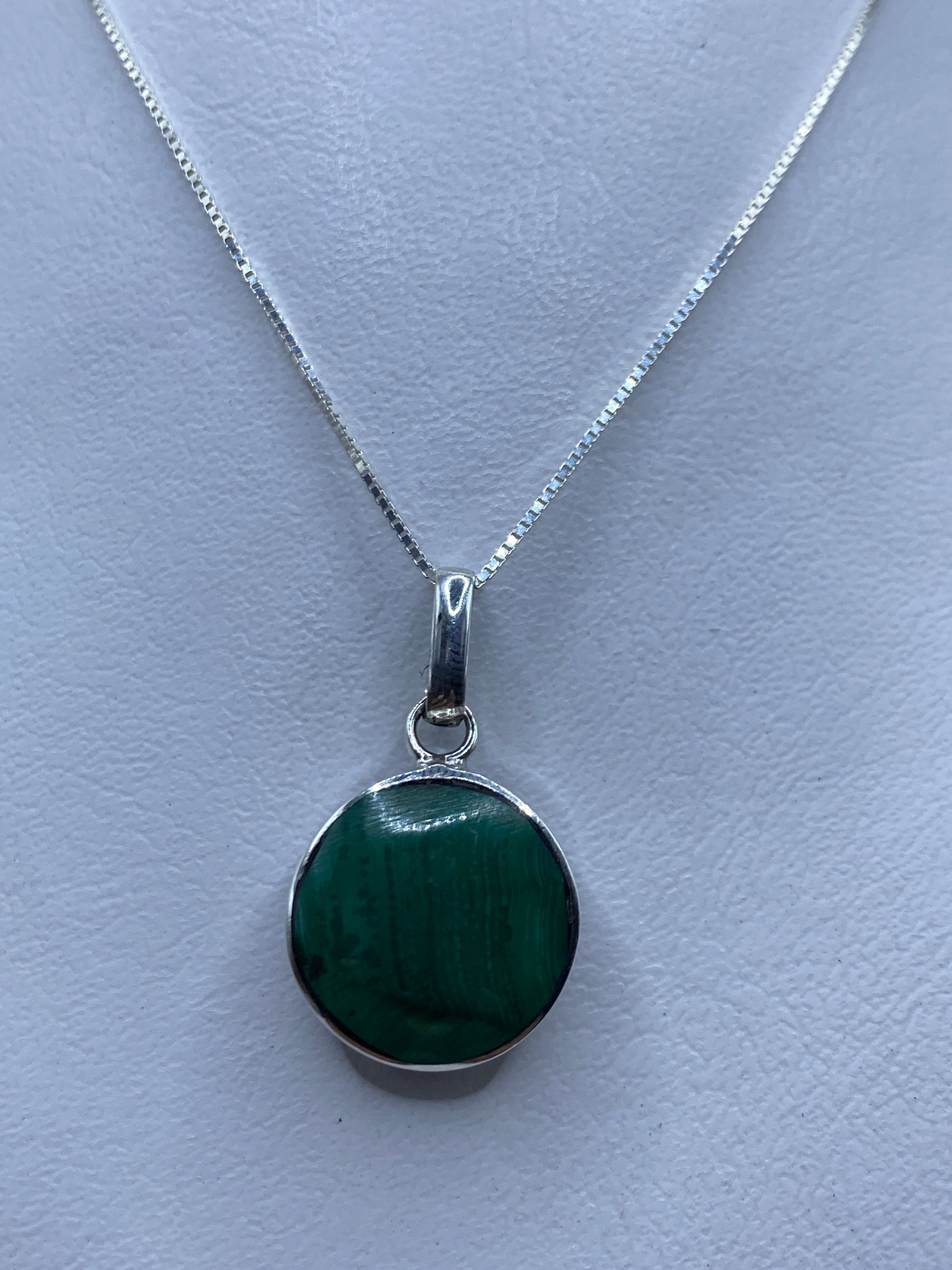 Dije de plata .925 con piedra azul colgado de una cadena plateada