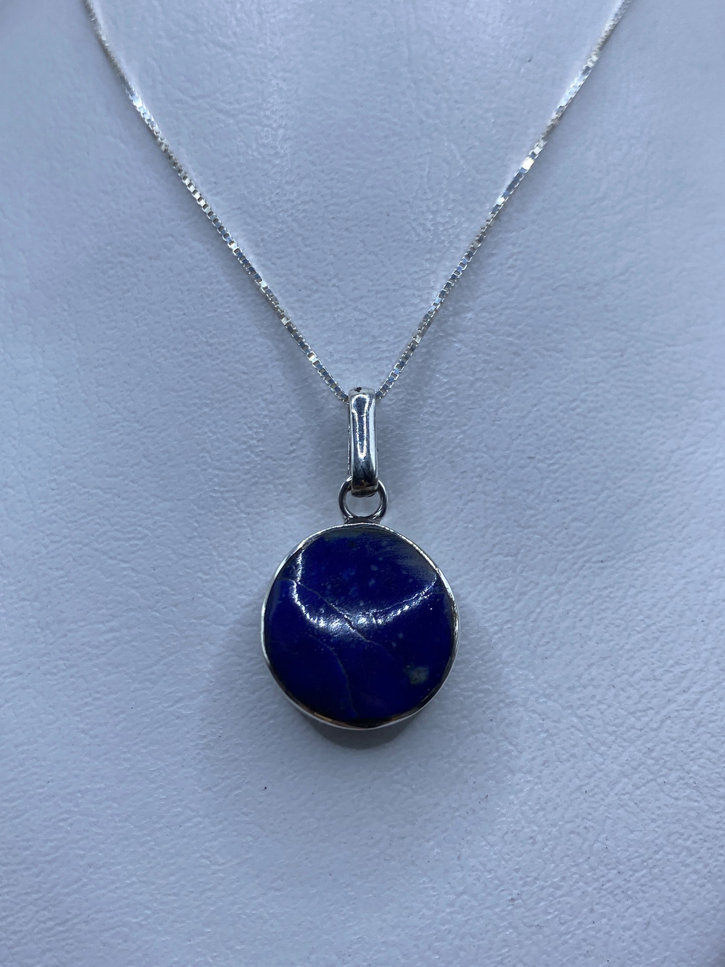 Detalle del dije de 3.3 cm mostrando la piedra azul engastada en plata