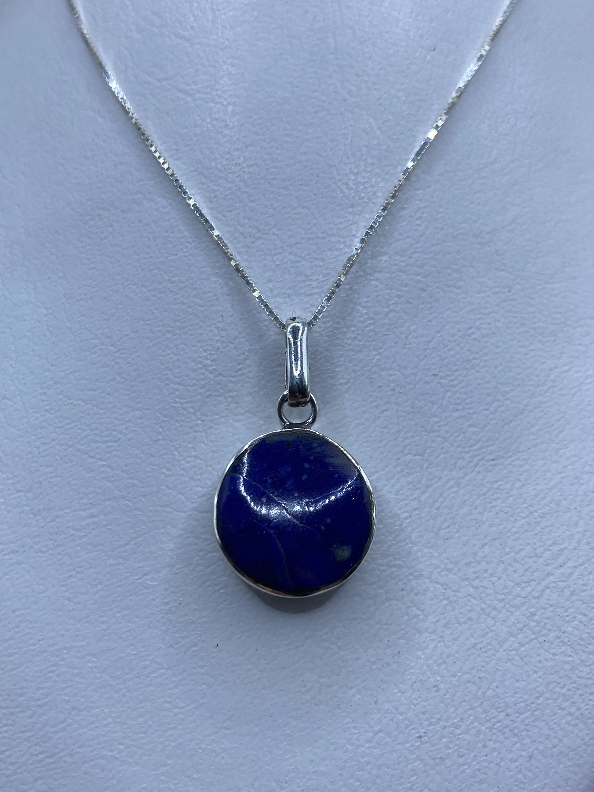 Detalle del dije de 3.3 cm mostrando la piedra azul engastada en plata