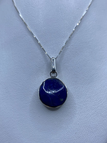 Detalle del dije de 3.3 cm mostrando la piedra azul engastada en plata