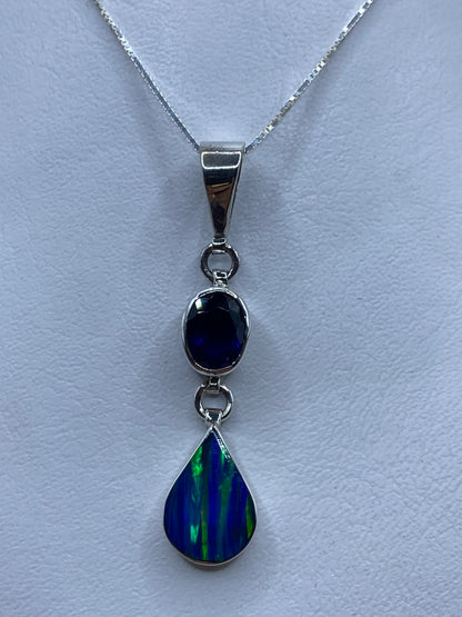 Dije de plata con ópalo de fuego azul colgando de una cadena de plata