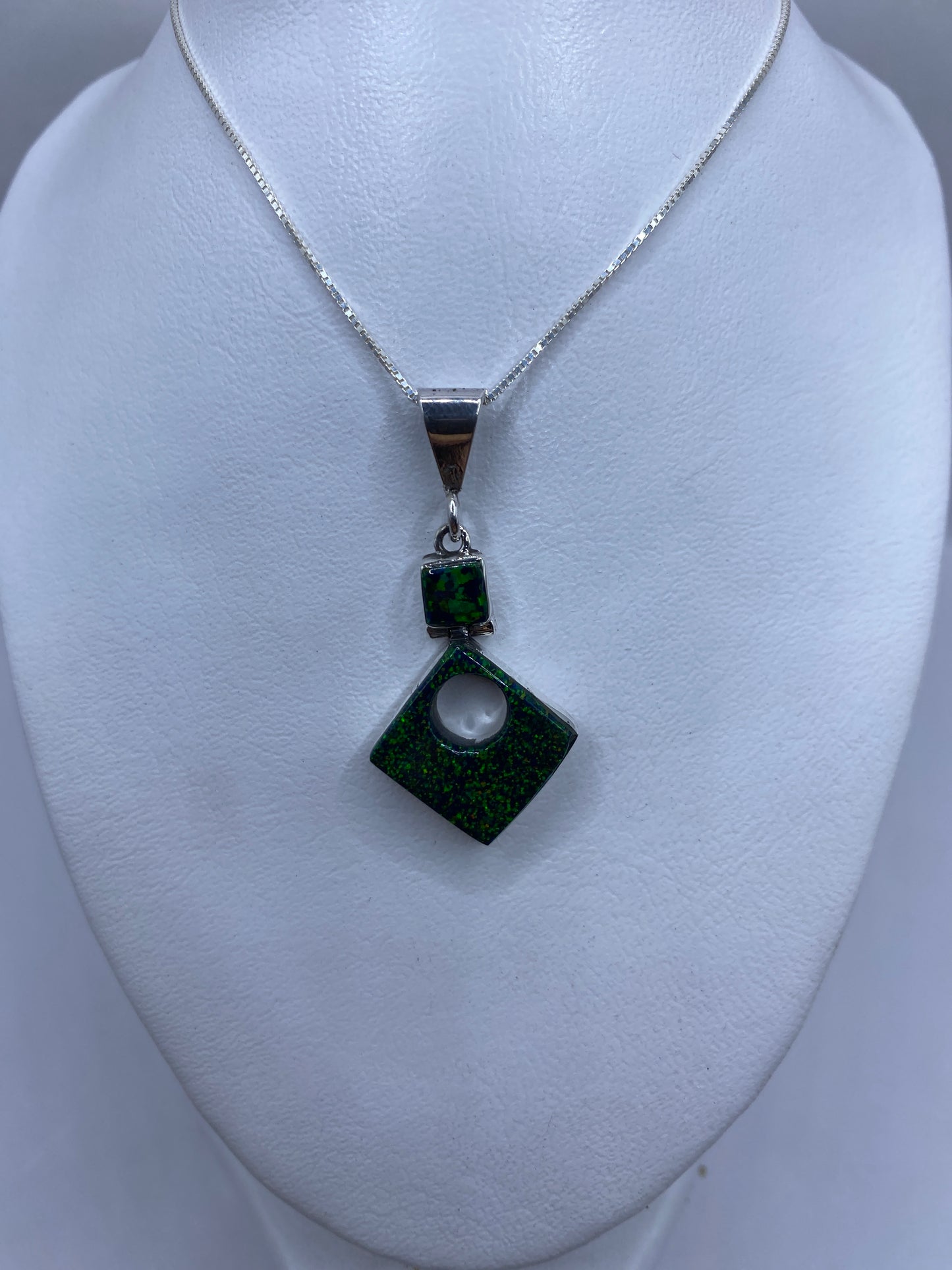 Dije de plata .950 con perforación central y marca de Quinto, sobre regla mostrando 4.7 cm