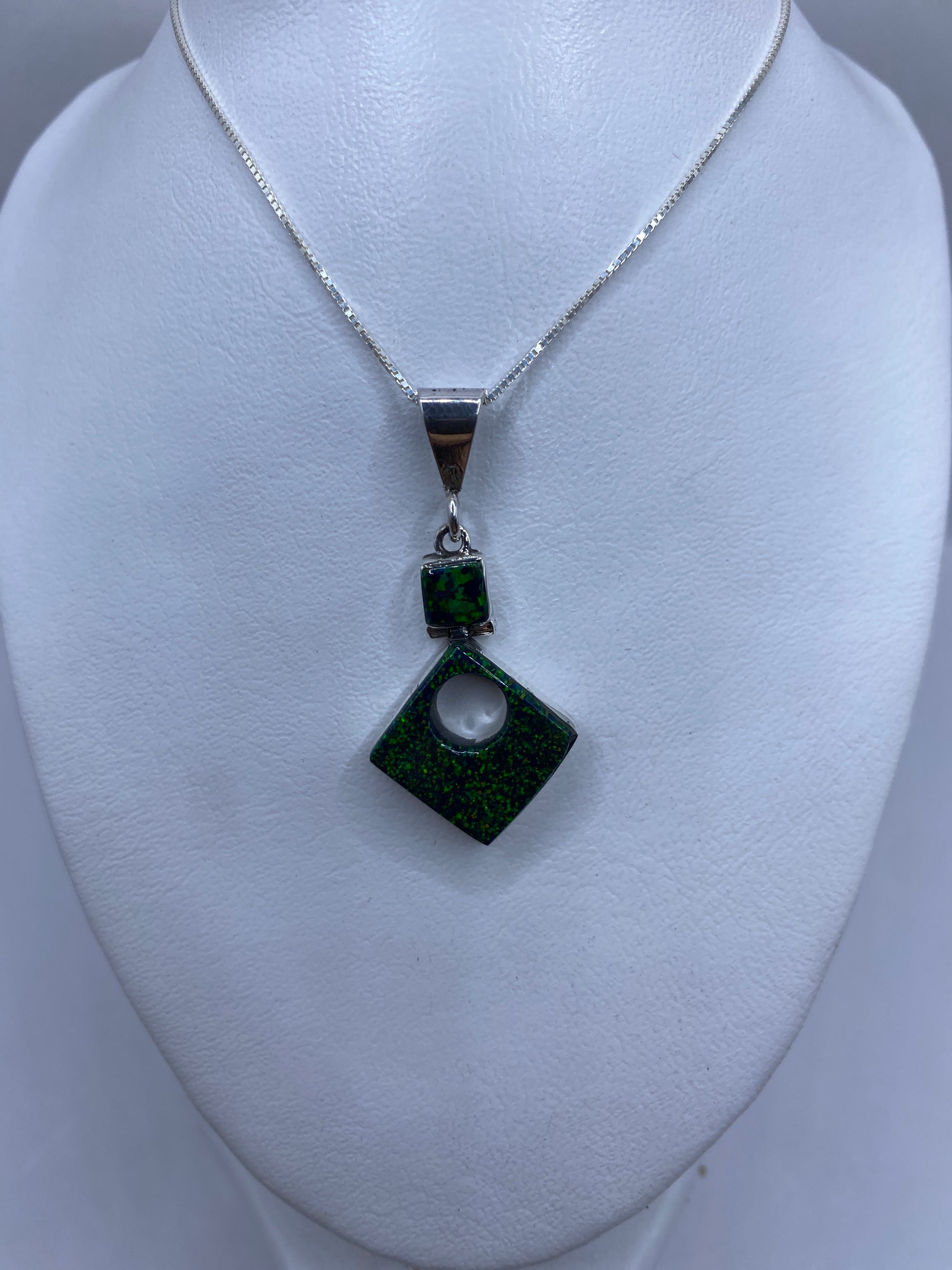 Dije de plata .950 con perforación central y marca de Quinto, sobre regla mostrando 4.7 cm