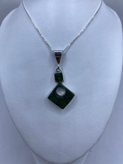 Dije de plata .950 con perforación central y marca de Quinto, sobre regla mostrando 4.7 cm