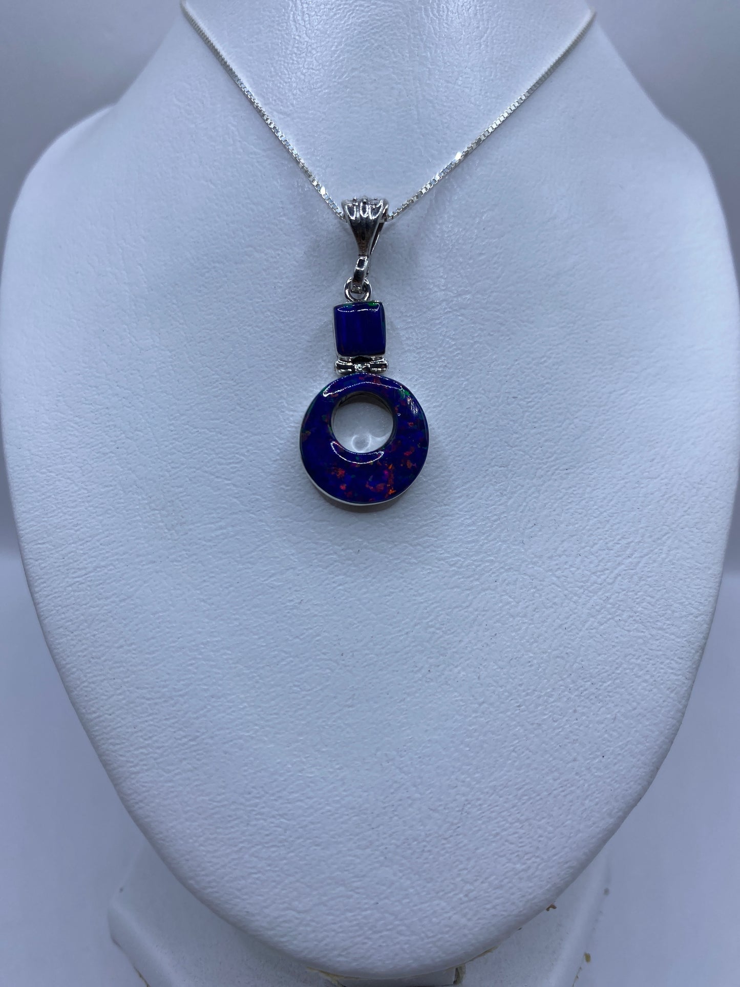 Detalle del ópalo de fuego azul engastado a mano en el dije de plata .950