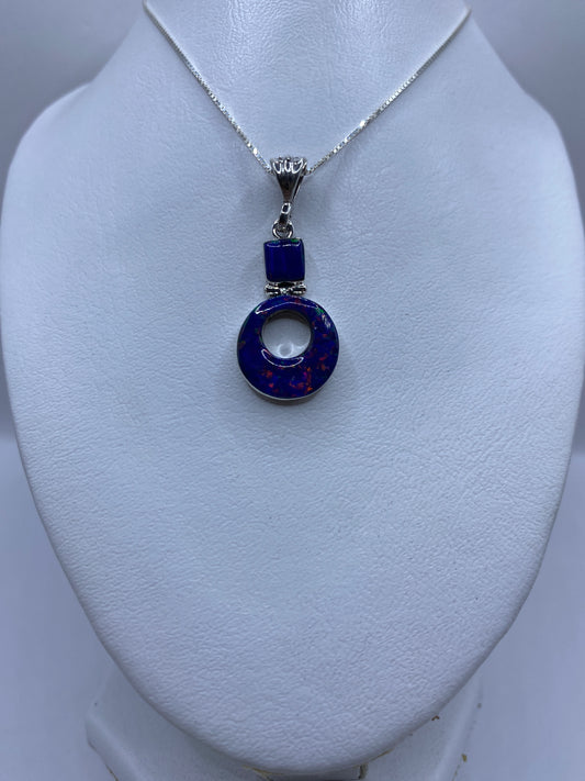 Detalle del ópalo de fuego azul engastado a mano en el dije de plata .950