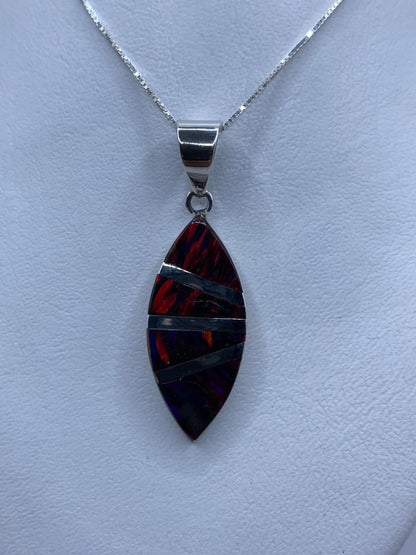 Dije ópalo de fuego multicolor en plata .950 colgado de cadena, mostrando colores naranjas y rojos