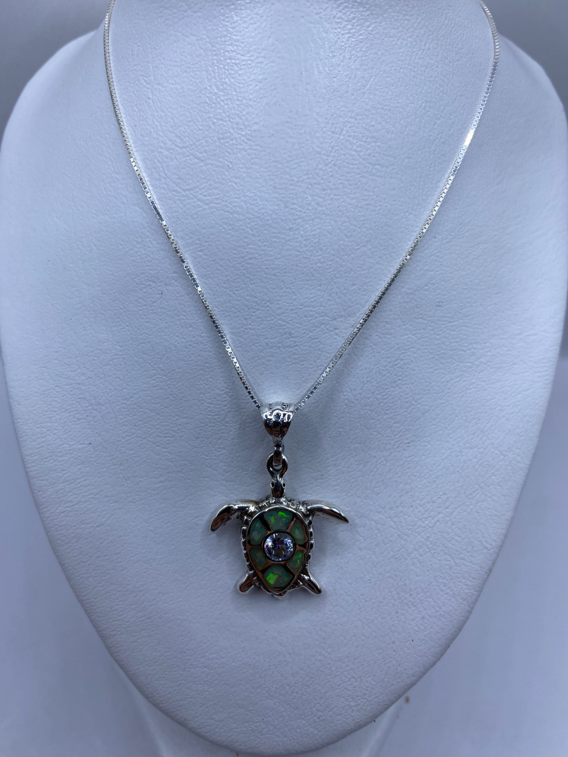 Detalle de la incrustación de piedra y las patas de la tortuga en plata
